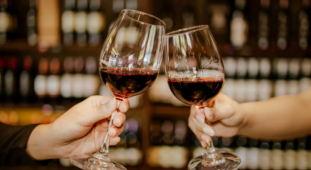 Two glasses of red wine in front of a wine display